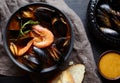 Spicy french soup bouillabaisse with seafood. Sauce Rouille. Traditional in France, Spain dish. Black background. Royalty Free Stock Photo