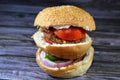 spicy fried beef burger cooked in a boiling shallow oil with slices of tomatoes, onions, bell peppers in burger bun topped with Royalty Free Stock Photo