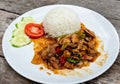 Spicy fried chicken with basil leaves,tomato,cucumber. Basil Fried Chicken.Spicy Thai basil chicken ready to eat on white plate. Royalty Free Stock Photo