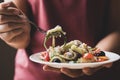 Spicy fruit and vegetables salad on white plate holding by hand Royalty Free Stock Photo