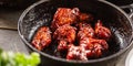 Spicy glazed marinated chicken wings in a dark pan