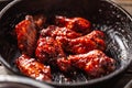 Spicy glazed marinated chicken wings in a dark pan