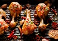 Spicy grilled chicken legs, drumsticks with the addition of chili peppers, garlic and herbs on the grill plate, top view. Royalty Free Stock Photo