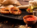 Spicy homemade sausages pork and beef sausages, on a wooden background, with sauce, spices and pickled cucumber . Template in