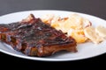 Spicy hot grilled spare ribs from BBQ served on a plate with paprika scalloped potatoes. Royalty Free Stock Photo