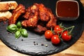 Spicy hot grilled spare ribs from a summer BBQ served with fresh tomatoes on an vintage cutting board Royalty Free Stock Photo