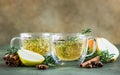 Spicy hot pear or apple cider with cinnamon, anise and rosemary. Traditional autumn or winter drinks. Green concrete background Royalty Free Stock Photo