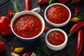 Spicy hot sweet chili sauce with mix of chilli pepper, garlic and tomatoes on rustic wooden background Royalty Free Stock Photo