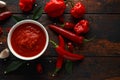 Spicy hot sweet chili sauce with mix of chilli pepper, garlic and tomatoes on rustic wooden background Royalty Free Stock Photo