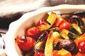 Spicy hot vegetables, cooked on an grill in ceramic bowl on wooden background. The concept of healthy eating and delicious food. Royalty Free Stock Photo