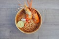 Spicy instant noodles soup with shrimp in wooden bowl on wood background,Tom yum kung Royalty Free Stock Photo