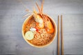 Spicy instant noodles soup with shrimp in wooden bowl on wood background,Tom yum kung Royalty Free Stock Photo