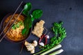 Spicy instant noodles soup And vegetables on a black background