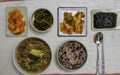 Spicy Korean beef stew and cooked rice with red beans served with seaweed and various Kimchi, pickled vegetables on a white table Royalty Free Stock Photo