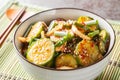 Spicy Korean cucumber salad in kimchi sauce with sesame seeds in a bowl with chopsticks. Horizontal Royalty Free Stock Photo