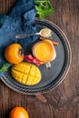 Spicy mango and persimmon smoothie with ginger and cinnamon in a glass jar for immunity and digestion