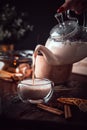 Spicy milk Indian tea Masala poured into a glass from a teapot. Aromatic hot drink Royalty Free Stock Photo