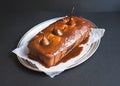 Spicy pear cake with caramel topping on a silver dish on a dark