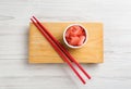 Spicy pickled ginger and chopsticks on white wooden table  top view Royalty Free Stock Photo