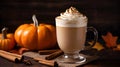 Spicy pumpkin latte with whipped cream and cinnamon over dark background with autumn leaves. A glass of creamy coffee with pumpkin