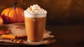 Spicy pumpkin latte with whipped cream and cinnamon over dark maroon autumn background. A glass of creamy coffee with pumpkin,