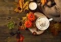 Spicy pumpkin latte with whipped cream cup and sweater, top view. Autumn coffee cup with pumpkin and cinnamon spice on wooden Royalty Free Stock Photo