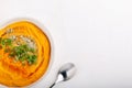 Spicy pumpkin soup served with pumpkin seeds and parsley.  Bowl with autumn squash soup on white table. Top view. Copy space Royalty Free Stock Photo