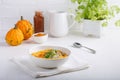 Spicy pumpkin soup served with pumpkin seeds and parsley.  Bowl with autumn squash soup on white table Royalty Free Stock Photo