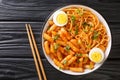 Spicy Rabokki is a variation of tteokbokki with ramen noodles served with boiled eggs closeup in the bowl. horizontal top view