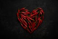 Spicy red chili pepper in the shape of a heart on a dark stone background Royalty Free Stock Photo