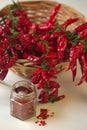 Spicy red pepper ground in the glass jar, with healthy dried peppers in the basket Royalty Free Stock Photo