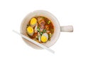 Spicy roll noodle brown broth soup with slice boiled eggs, liver, crispy pork, bean sprouts, green onion leaf, cayenne pepper