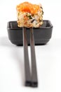 Spicy roll with tobiko caviar, sauce and chopsticks
