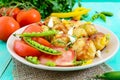 Spicy salad of baked potatoes, young garlic, tomatoes, green peas Royalty Free Stock Photo