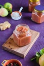 Spicy sauce, apple chutney in a glass jar on a wooden board on a purple concrete background. Indian food Royalty Free Stock Photo