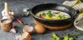 spicy scrambled eggs or omlette in a frying pan with bacon, garlic and pepper, ingredients around on the tables Royalty Free Stock Photo