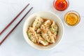 Spicy Sichuan / Schezwan Chicken Dumplings / Wonton Garnished with Chives and Sesame Seeds on White Background with Chopsticks