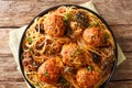 Spicy spaghetti with meatballs and mushroom gravy close-up in a plate. Horizontal top view Royalty Free Stock Photo
