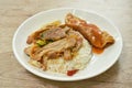 Spicy stir fried barbecue pork neck with chili and basil leaf topping egg dressing sauce and rice on plate