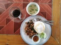 spicy stir fried mint pork with fried egg served with soup and coffee