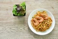 Spicy stir fried spaghetti shrimp with chili and basil leaf in tom yum sauce on plate eat couple fresh vegetable salad Royalty Free Stock Photo
