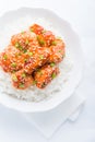 Spicy sweet and sour chicken with sesame and rice top view on white background