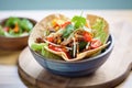 spicy taco salad in a tortilla bowl with cheese