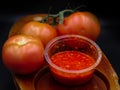 spicy tomato sauce, and tomato\'s in a wood plait ,black background