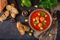 Spicy tomato soup with meatballs and vegetables. Served with avocado and parsley. Healthy dinner.Flat lay. Royalty Free Stock Photo