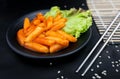 Spicy Tteokbokki on black crockery.