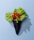 SPICY TUNA wrap topping with salad leaves isolated on sky blue background top view fast food
