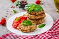 Spicy vegan burgers with rice, chickpeas and herbs. Salad tomato and basil.