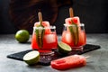 Spicy watermelon popsicle margarita cocktail with jalapeno and lime. Mexican alcoholic drink for Cinco de mayo party.