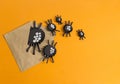 Spiders from paper crawl out of the envelope. Orange background.